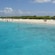 People stand on an island and swim near boats